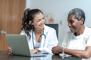 Doctor working with patient on laptop in hospital