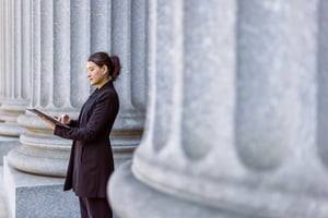 Female government worker using iPad outside of government building.
