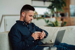 Man looking at his watch while on laptop