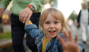 A little girl waving at the screen
