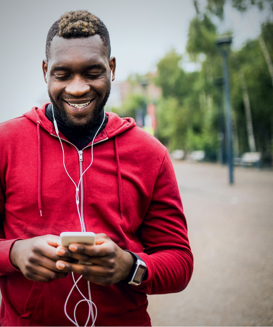 Man smiling at phone outside Man smiling at phone outside