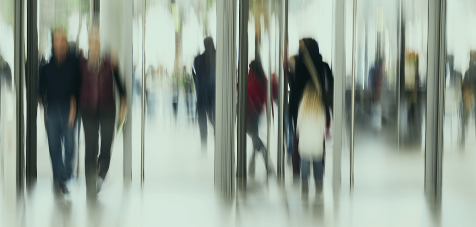 Blurred figures move through a modern glass entrance with multiple doorways, evoking the challenge of navigating a digital front door.
