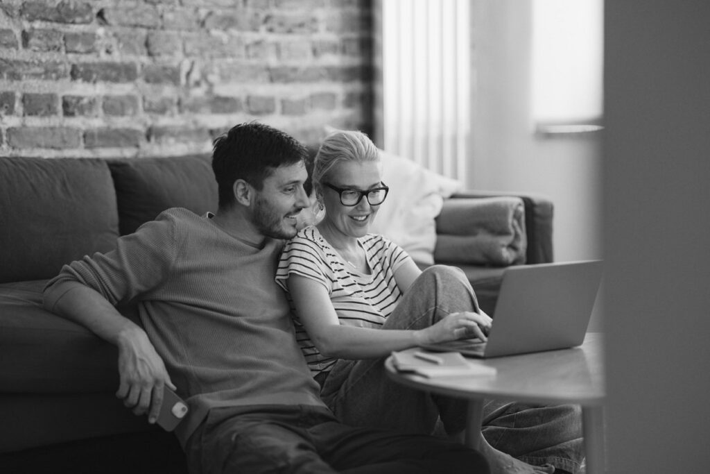 Couple Using Laptop Smiling BW