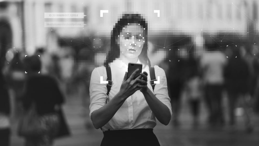 Privacy By Design Woman holding phone in a secure browser preventing unwanted facial recognition BW
