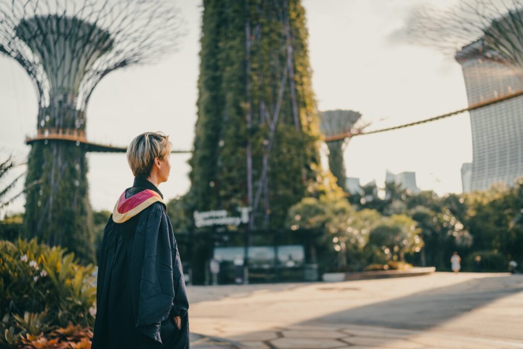 University student in graduation gown outside in university campus yard