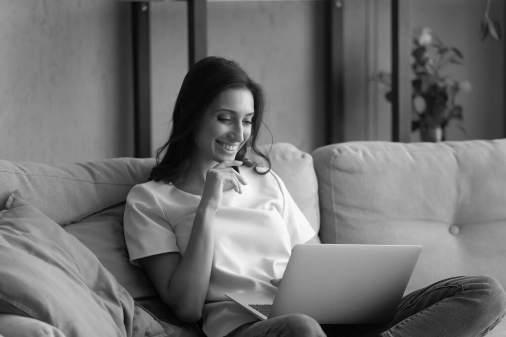 Woman smiling using laptop in her home vignette